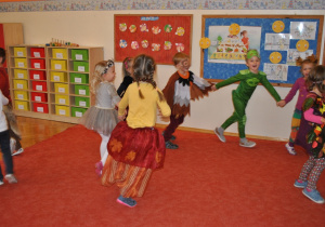 Grupa dzieci tańczy prowadzona w wężyku. Ujęcie 1
